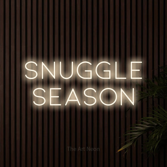 Warm white LED neon sign reading "Snuggle Season" against dark wooden slats for bedroom décor