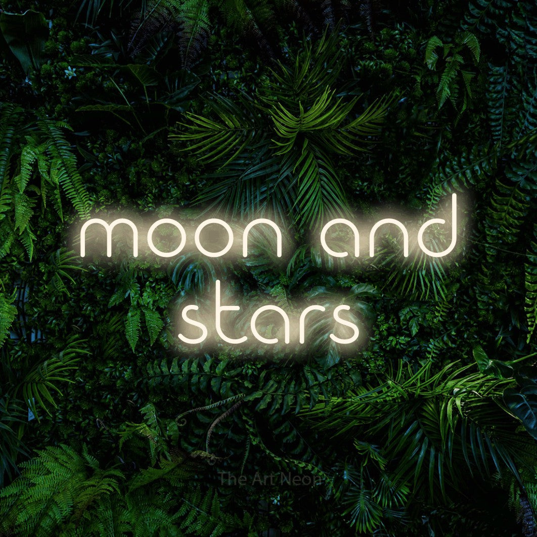 Warm white LED neon sign reading "Moon and Stars" against a dense tropical foliage wall for bedroom décor