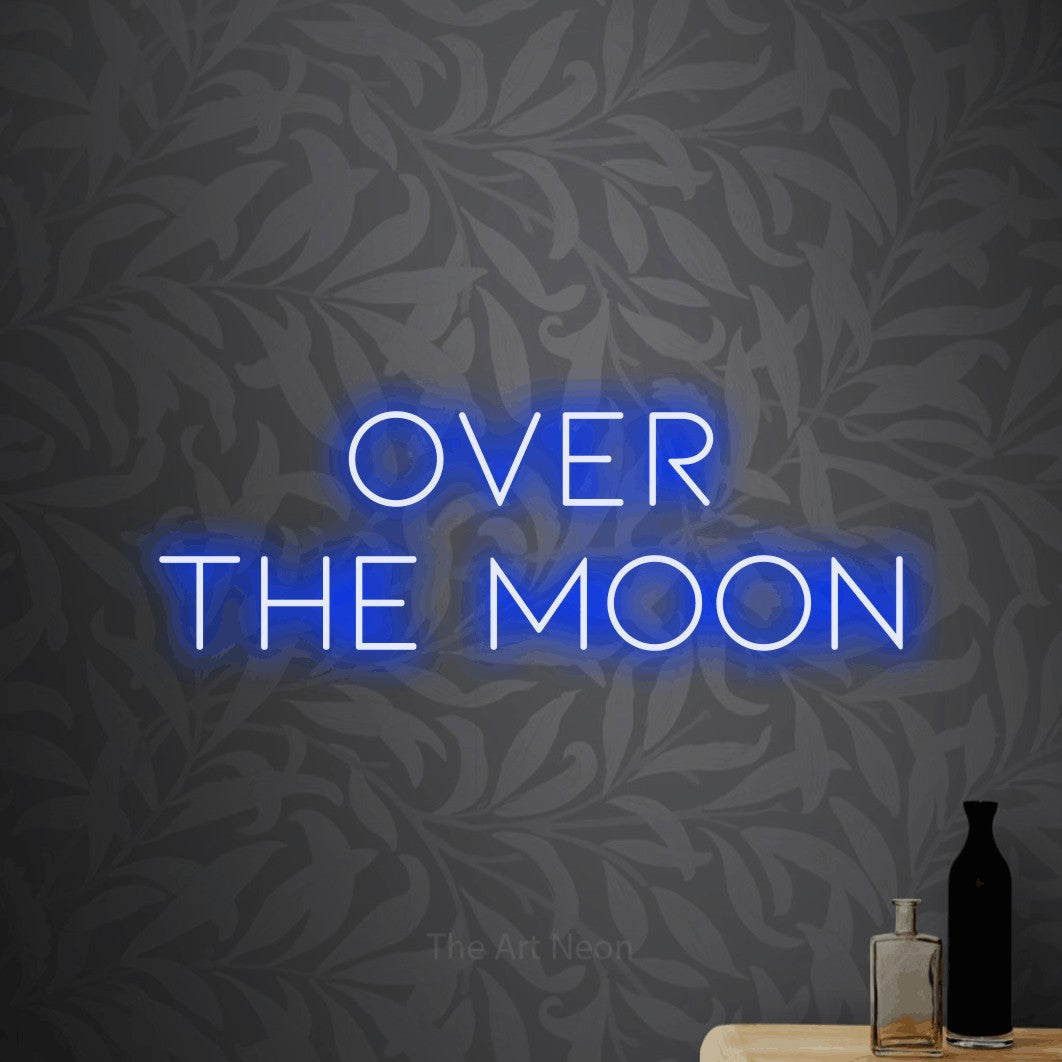 Blue LED neon sign reading "Over the Moon" against light grey floral wallpaper for bedroom décor
