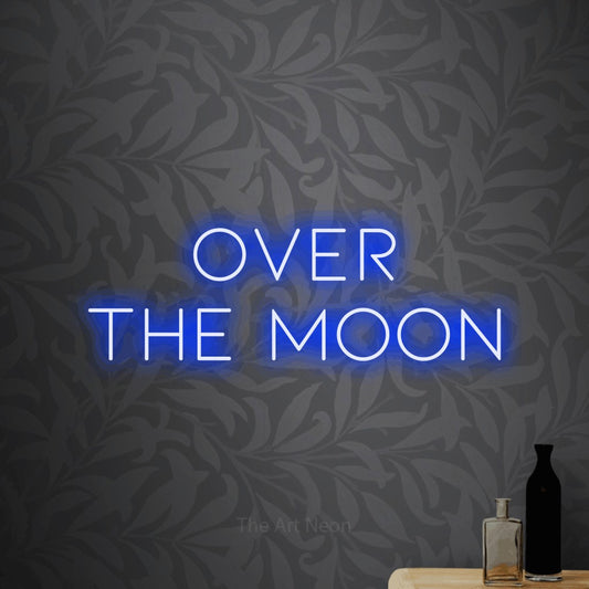 Blue LED neon sign reading "Over the Moon" against light grey floral wallpaper for bedroom décor