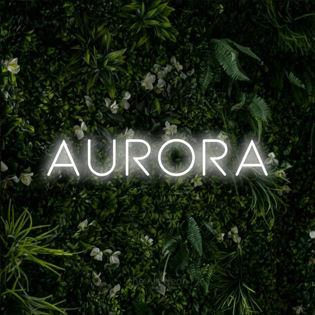 Cool white LED neon sign reading "Aurora" against a leafy green wall for bedroom décor