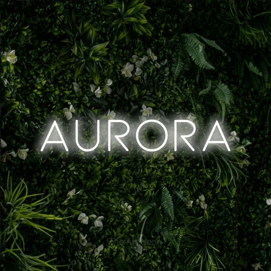 Cool white LED neon sign reading "Aurora" against a leafy green wall for bedroom décor