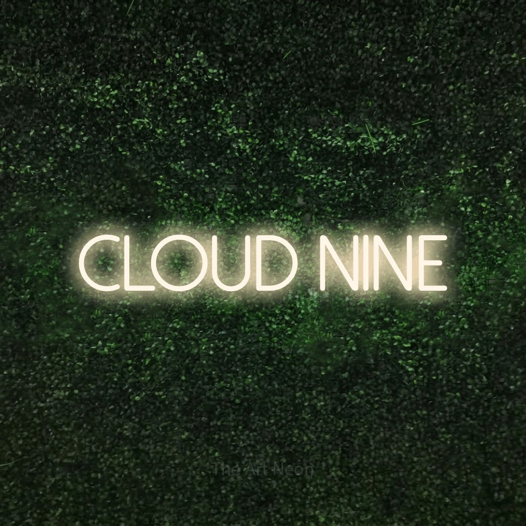 Warm white LED neon sign reading "Cloud Nine" against a textured green moss wall for bedroom décor
