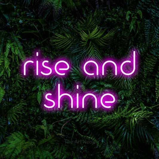 Pink LED neon sign reading "Rise and Shine" against a dense tropical foliage wall for bedroom décor