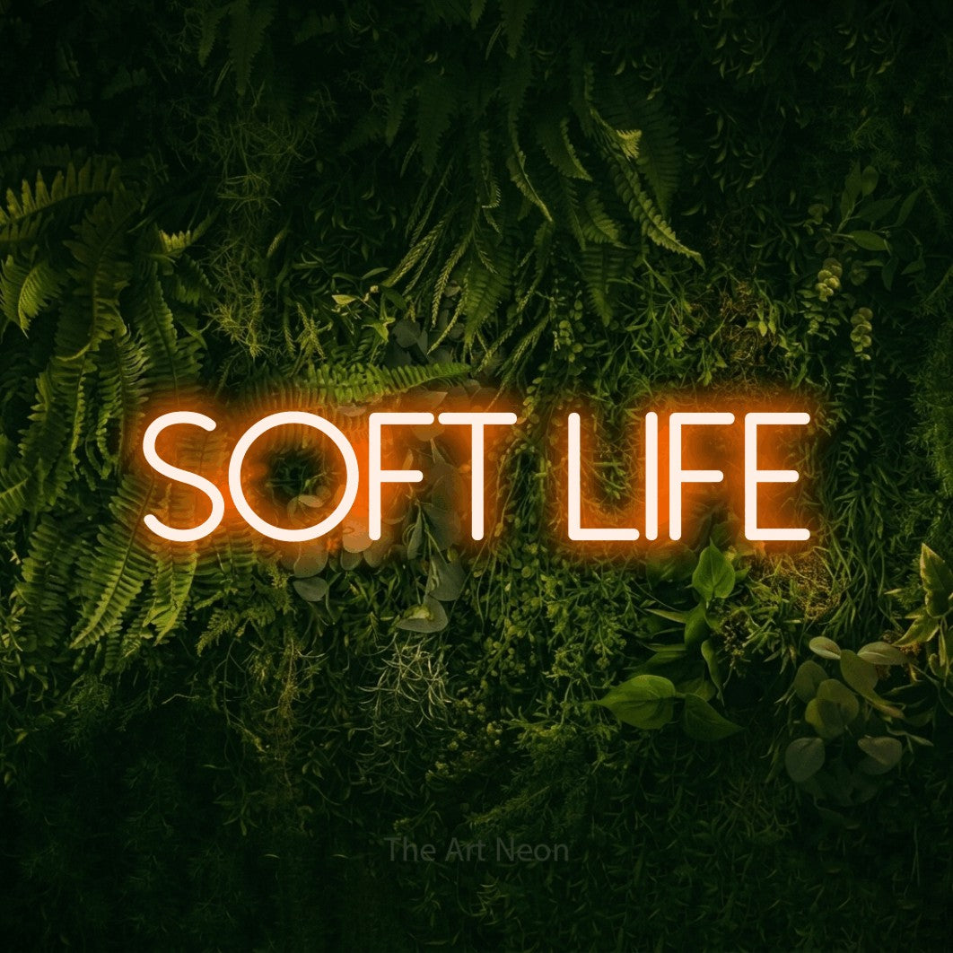 Orange LED neon sign reading "Soft Life" against a moss-covered green wall for bedroom décor
