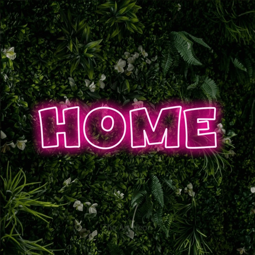 Hot pink outline-style LED neon sign reading "Home" against a leafy green wall for living room décor