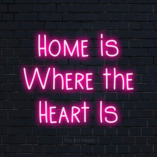 Hot pink LED neon sign reading "Home is Where the Heart Is" against a dark navy brick wall for living room décor