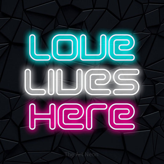 Multicolour outline-style LED neon sign reading "Love Lives Here" against a black faceted wall for living room décor