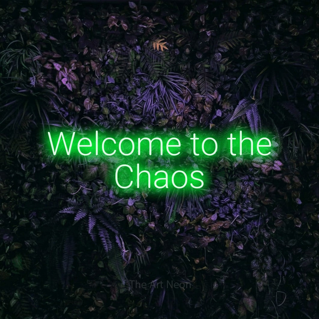 Green LED neon sign reading "Welcome to the Chaos" against a purple floral wall for living room décor