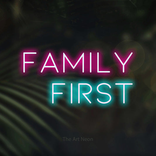 Ice blue and hot pink LED neon sign reading "Family First" against dark blurred palm leaves for living room décor