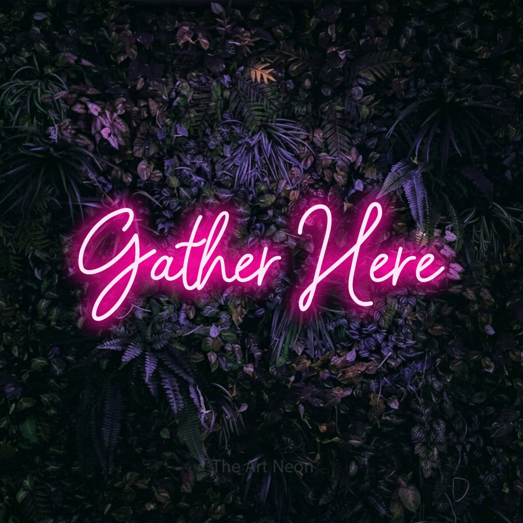 Hot pink script-style LED neon sign reading "Gather Here" against a purple floral wall for living room décor
