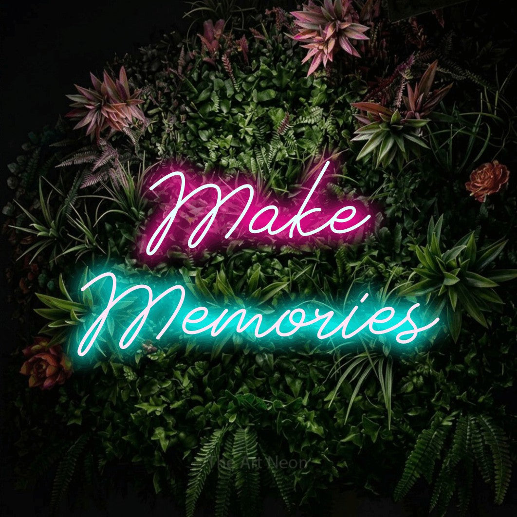Ice blue and hot pink script-style LED neon sign reading "Make Memories" against a flowering garden wall
