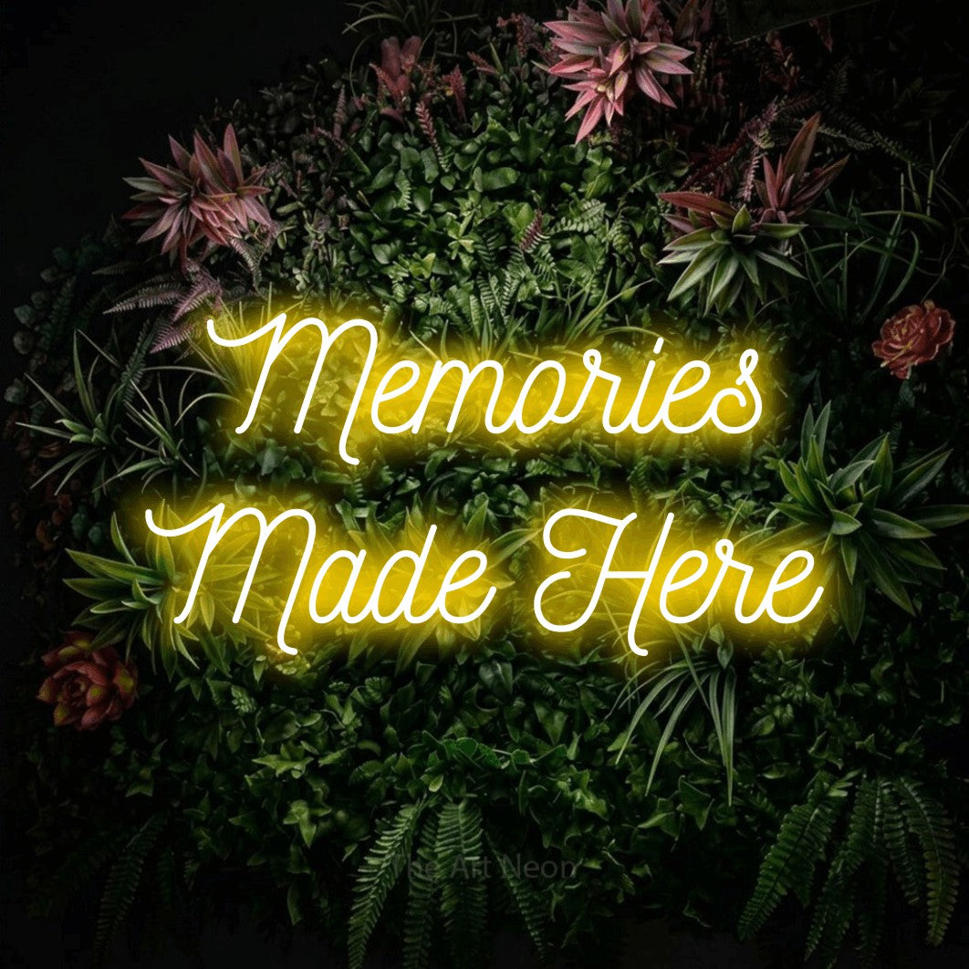 Yellow script-style LED neon sign reading "Memories Made Here" against a flowering garden wall for living room décor
