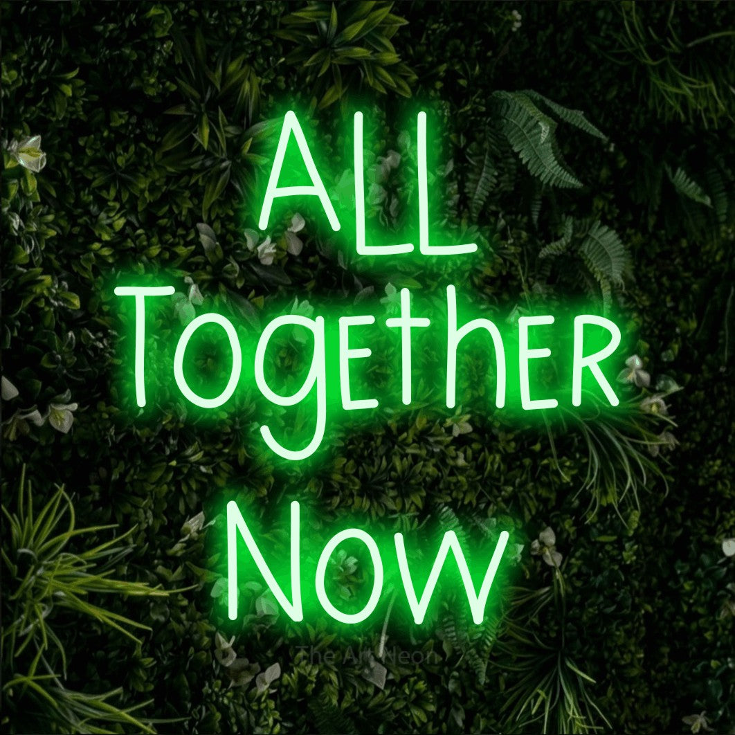 Green LED neon sign reading "All Together Now" against a leafy green wall for living room décor