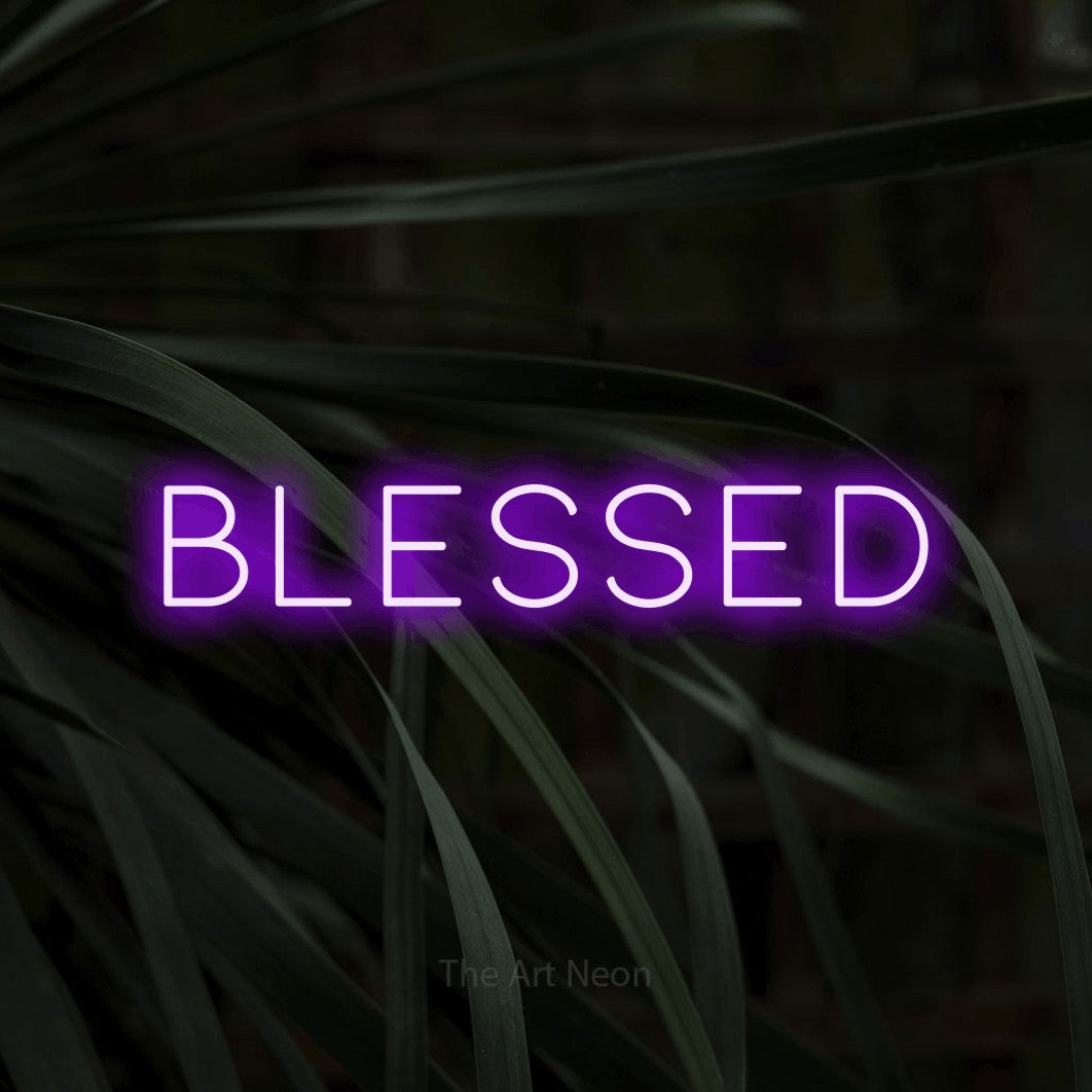 Purple LED neon sign reading "Blessed" against dark tropical leaves for living room décor