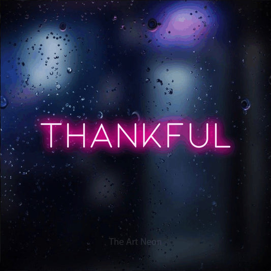 Enseigne néon à DEL à lumière rose vif, affichant « Thankful » sur un arrière-plan bokeh bleu foncé, pour décorer un salon