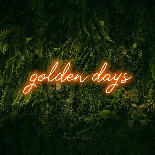 Enseigne néon à DEL à lumière orange, de style manuscrit, affichant « Golden Days » sur un mur vert couvert de mousse, pour décorer un salon