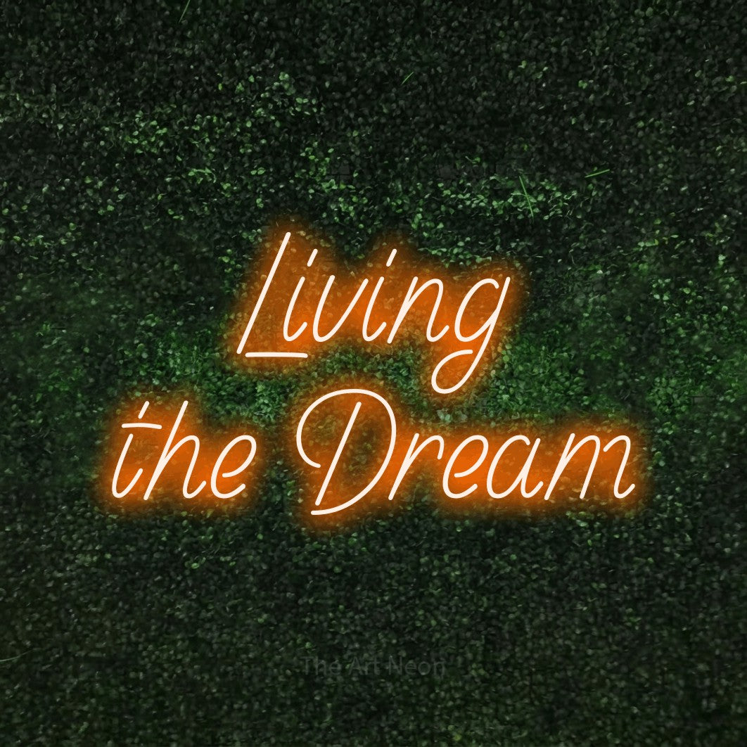 Orange LED neon sign reading "Living the Dream" against a textured green moss wall for living room décor
