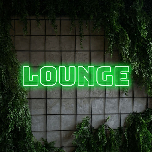 Green outline-style LED neon sign reading "Lounge" against a green grid wall with foliage for living room décor