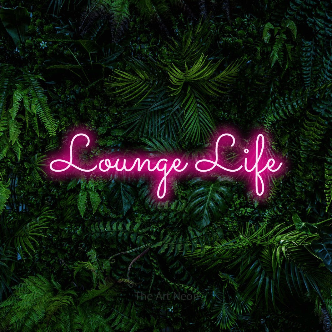 Hot pink LED neon sign reading "Lounge Life" against a dense tropical foliage wall for living room décor