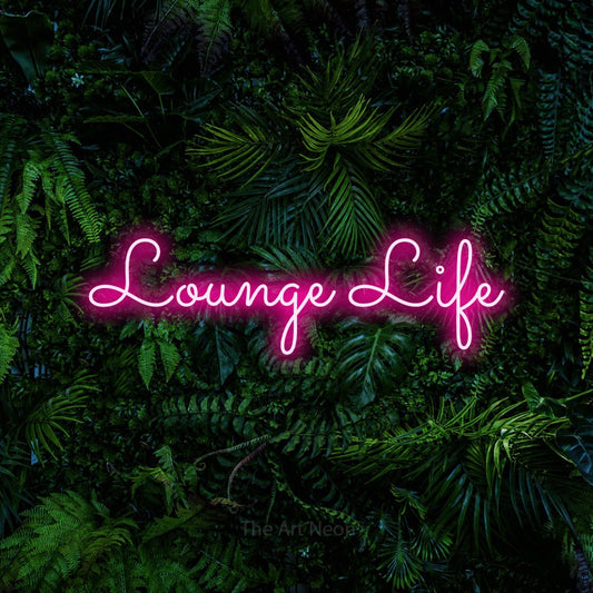 Hot pink LED neon sign reading "Lounge Life" against a dense tropical foliage wall for living room décor