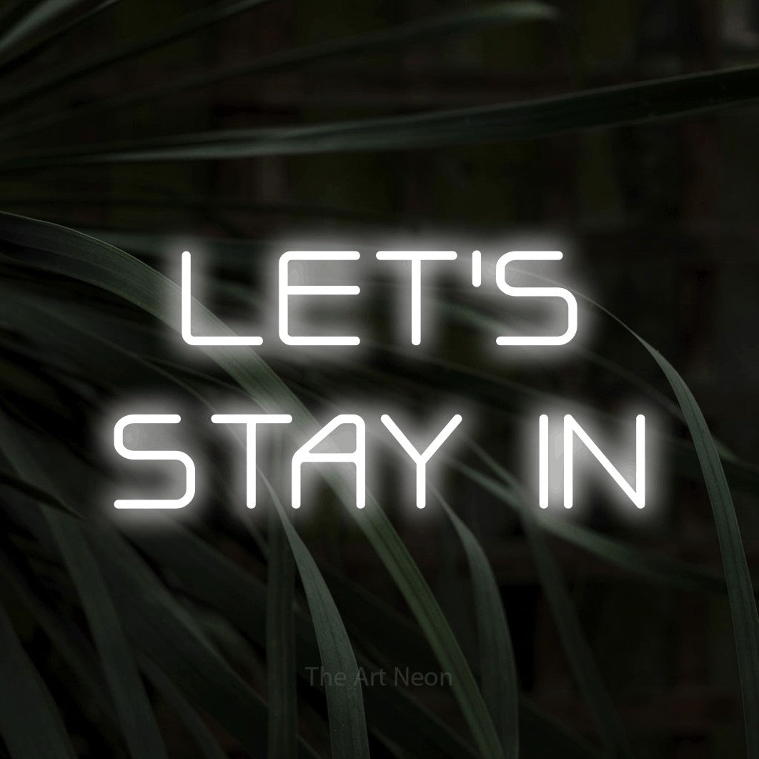Cool white LED neon sign reading "Let's Stay In" against dark tropical leaves for living room décor