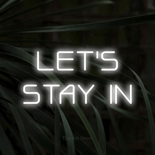 Cool white LED neon sign reading "Let's Stay In" against dark tropical leaves for living room décor