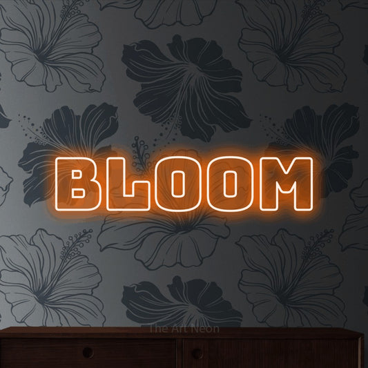 Orange outline-style LED neon sign reading "Bloom" against grey floral wallpaper for living room décor