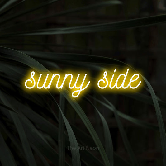 Yellow script-style LED neon sign reading "Sunny Side" against dark tropical leaves for living room décor