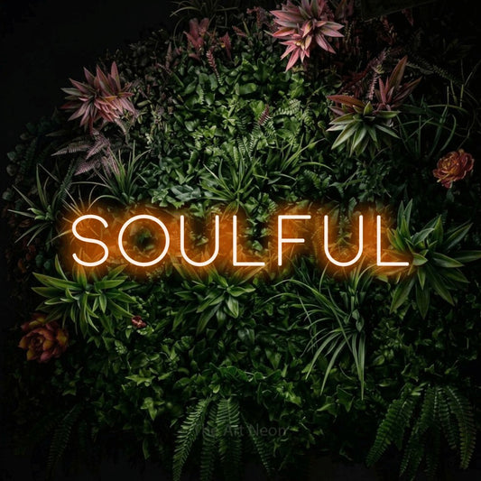Orange LED neon sign reading "Soulful" against a flowering garden wall for living room décor