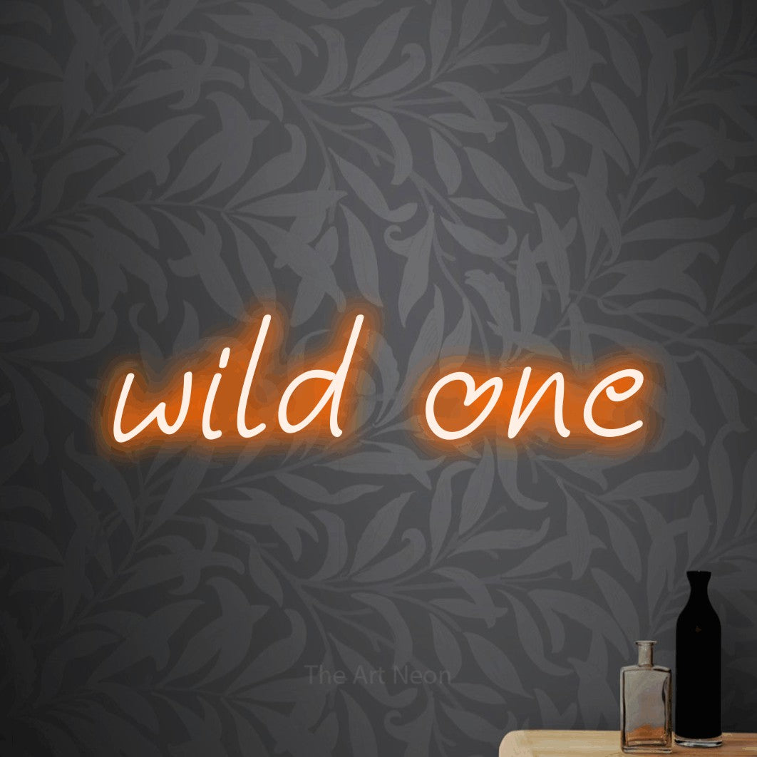 Enseigne néon à DEL à lumière orange, affichant « Wild One » sur un papier peint floral gris pâle, pour décorer une chambre de bébé
