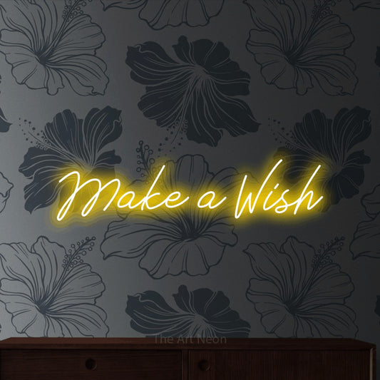 Enseigne néon à DEL à lumière jaune, de style manuscrit, affichant « Make a Wish » sur un papier peint floral gris, pour décorer une chambre de bébé