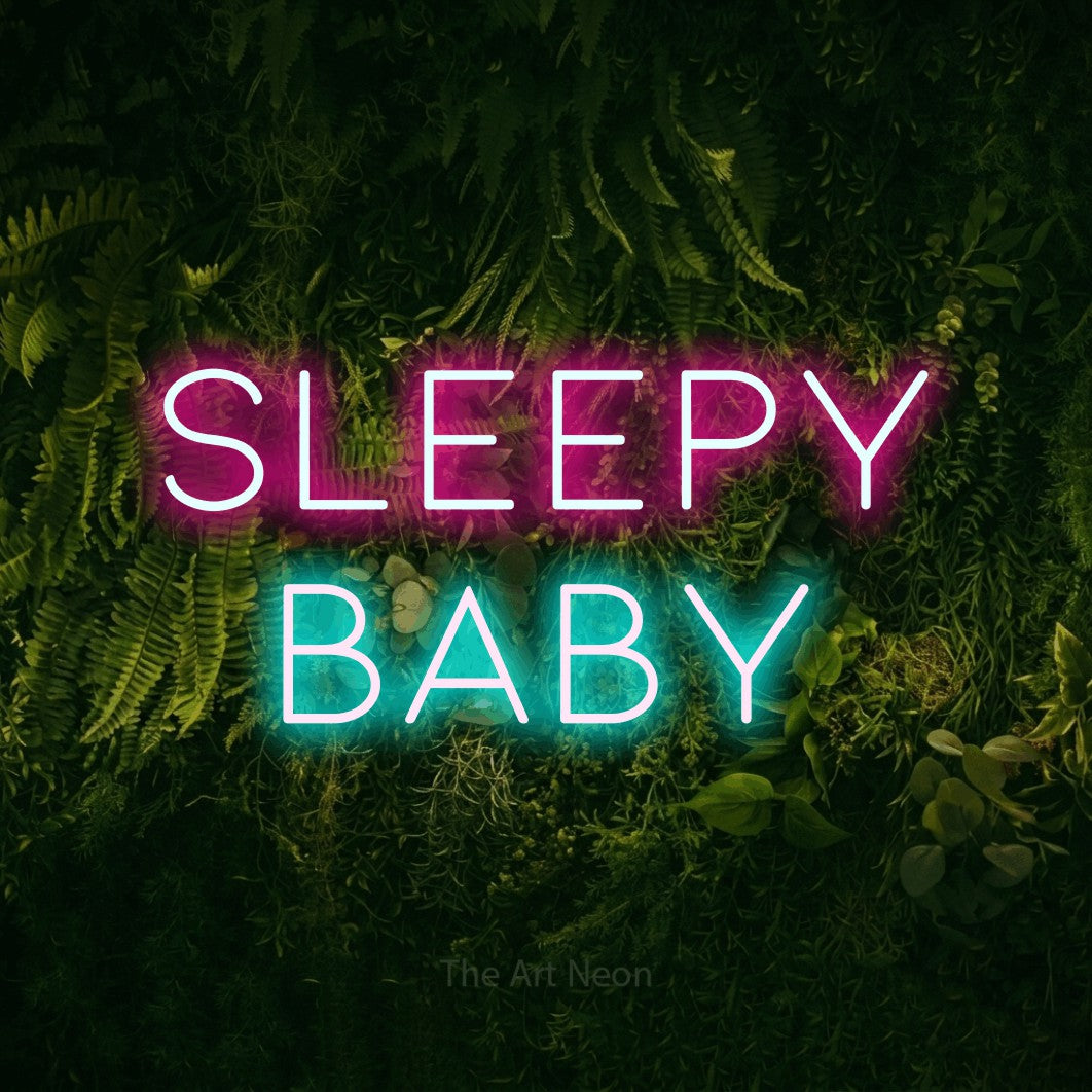 Enseigne néon à DEL à lumière bleu glacier et rose vif, affichant « Sleepy Baby » sur un mur vert couvert de mousse, pour décorer une chambre de bébé