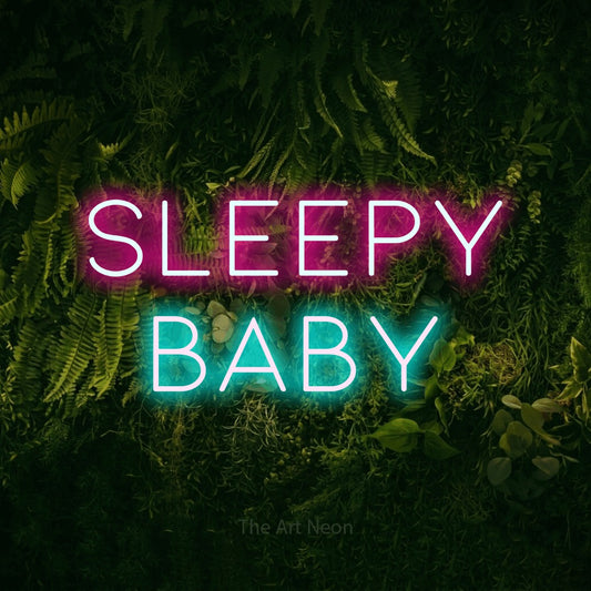 Enseigne néon à DEL à lumière bleu glacier et rose vif, affichant « Sleepy Baby » sur un mur vert couvert de mousse, pour décorer une chambre de bébé