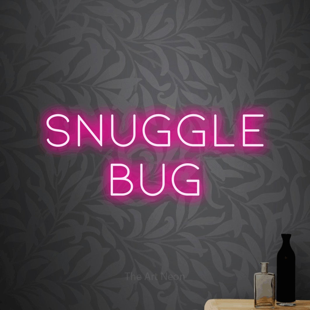 Enseigne néon à DEL à lumière rose vif, affichant « Snuggle Bug » sur un papier peint floral gris pâle, pour décorer une chambre de bébé