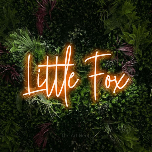 Enseigne néon à DEL à lumière orange, de style manuscrit, affichant « Little Fox » sur un mur de jardin luxuriant aux fleurs roses, pour décorer une chambre de bébé