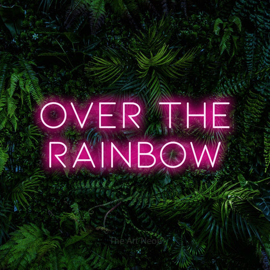 Hot pink LED neon sign reading "Over the Rainbow" against a dense tropical foliage wall for nursery décor