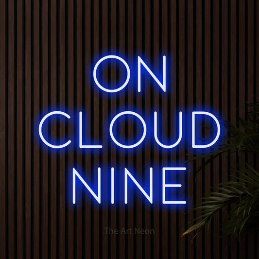 Blue LED neon sign reading "On Cloud Nine" against dark wooden slats for nursery décor