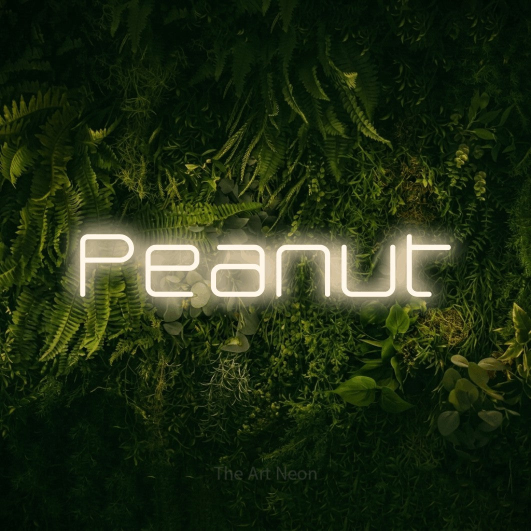 Warm white LED neon sign reading "Peanut" against a moss-covered green wall for nursery décor