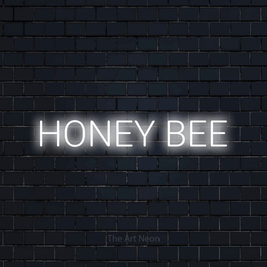 Cool white LED neon sign reading "Honey Bee" against a dark navy brick wall for nursery décor