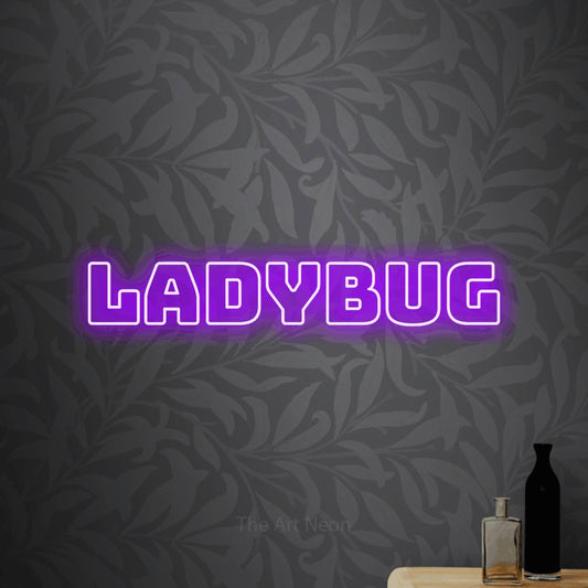 Purple outline-style LED neon sign reading "Ladybug" against light grey floral wallpaper for nursery décor