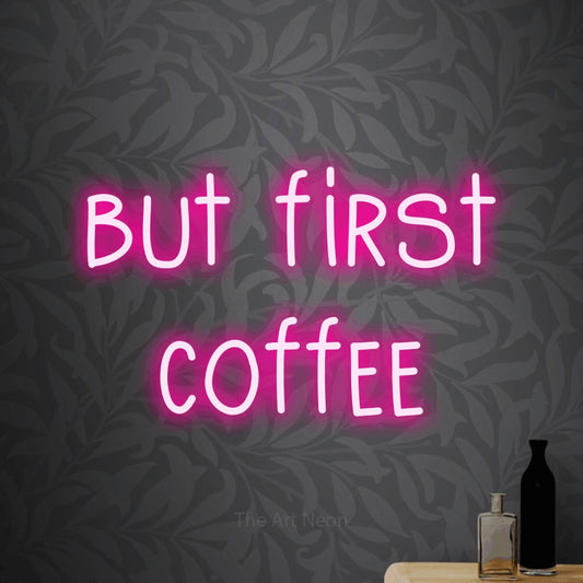 Hot pink LED neon sign reading "But First Coffee" against light grey floral wallpaper for kitchen décor