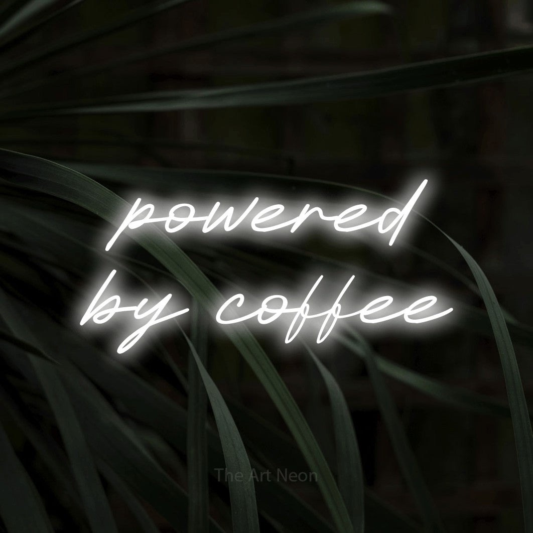 Cool white LED neon sign reading "Powered by Coffee" against dark tropical leaves for kitchen décor
