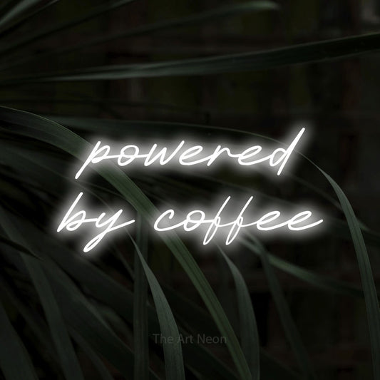 Cool white LED neon sign reading "Powered by Coffee" against dark tropical leaves for kitchen décor
