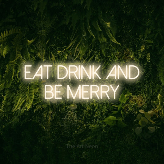 Warm white LED neon sign reading "Eat Drink and Be Merry" against a moss-covered green wall for kitchen décor