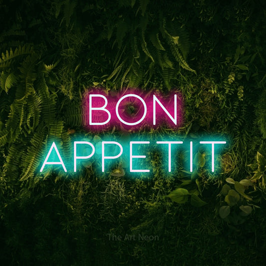 Ice blue and hot pink LED neon sign reading "Bon Appetit" against a moss-covered green wall for kitchen décor