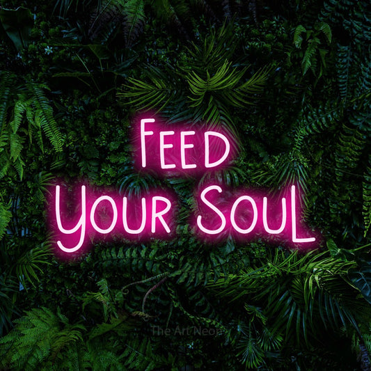 Hot pink LED neon sign reading "Feed Your Soul" against a dense tropical foliage wall for kitchen décor
