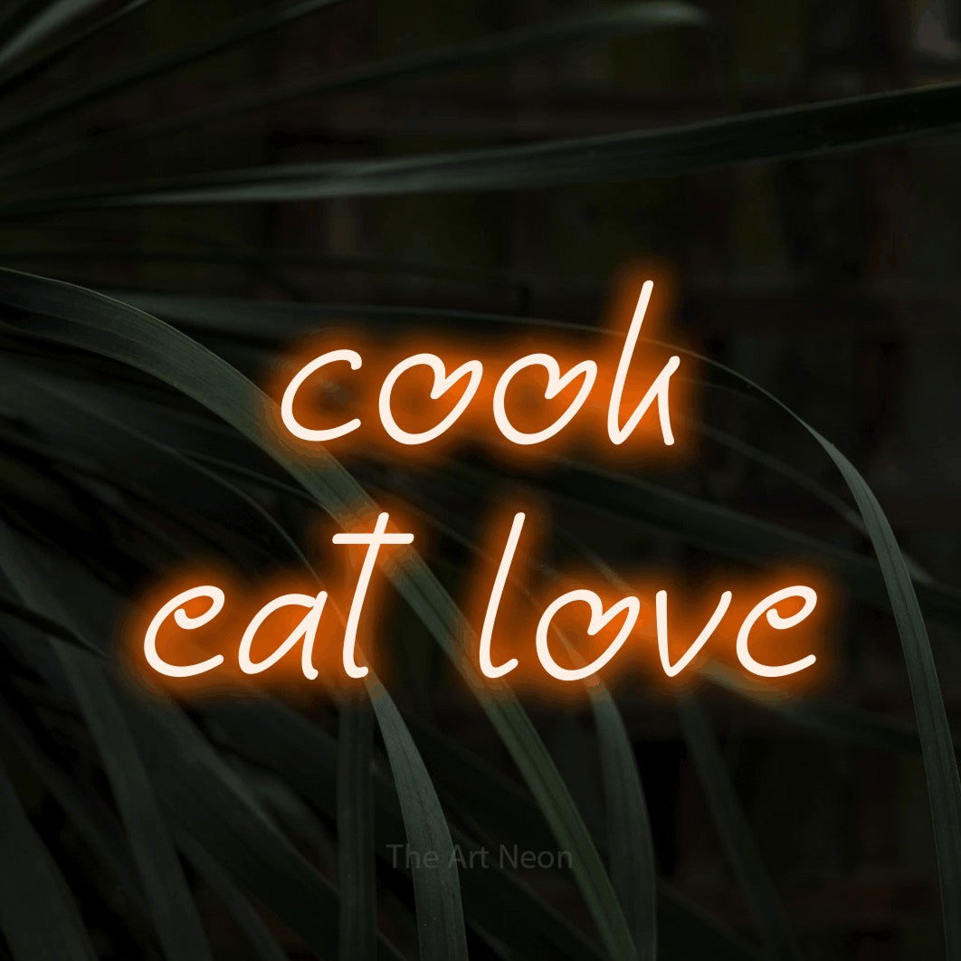 Enseigne néon à DEL à lumière orange, affichant « Cook Eat Love » sur des feuilles tropicales foncées, pour décorer une cuisine