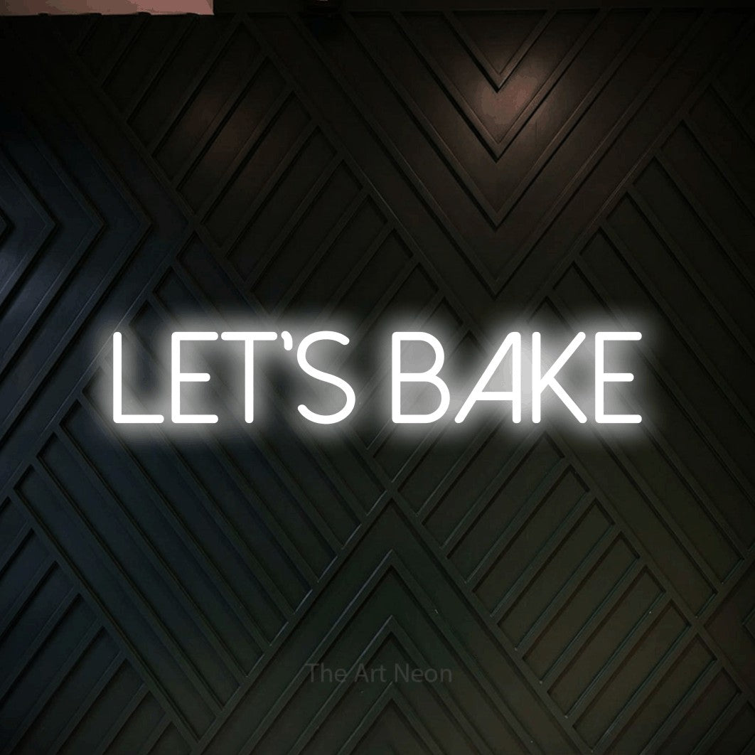Cool white LED neon sign reading "Let's Bake" against a dark geometric wood wall for kitchen décor