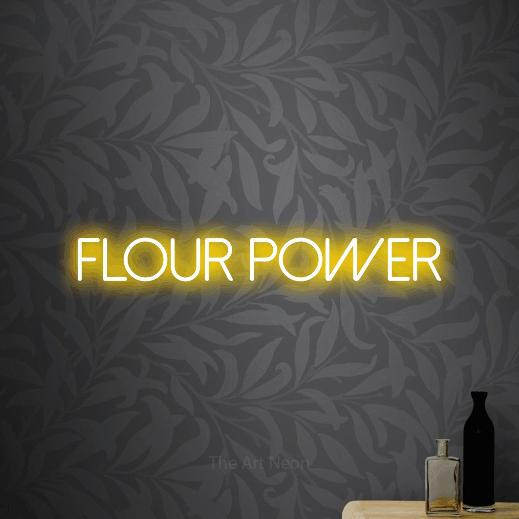 Yellow LED neon sign reading "Flour Power" against light grey floral wallpaper for kitchen décor